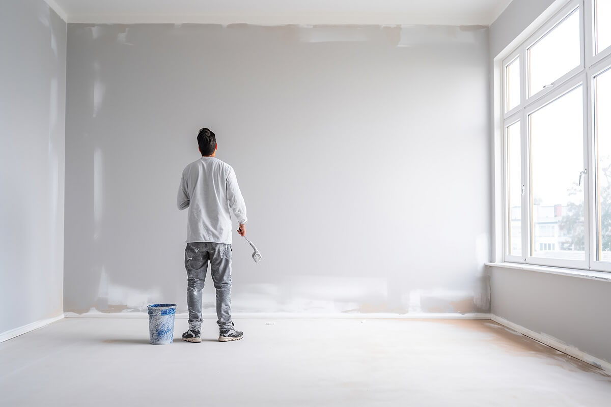Pracownik szpachluje ściany, przygotowując je do malowania
